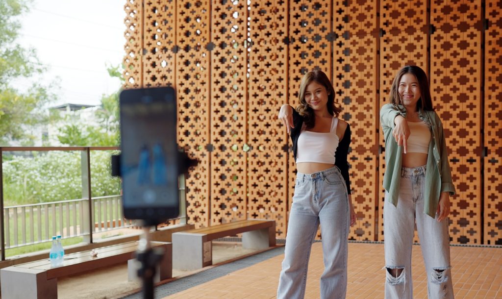 Gen z vlogger influencer asia teen girl trending relax smile moving dance at city park street record on IG reel tiktok instagram app young youtuber play fun joy selfie post show share viral vlog video